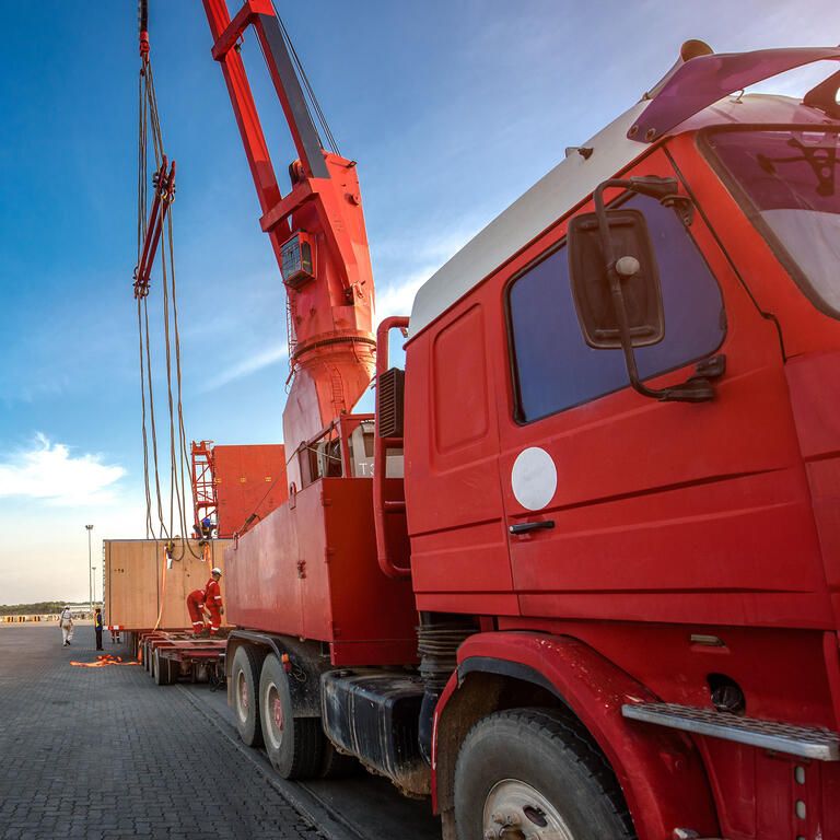 transportation of the logistics services on the heavy lift cargo transfer loading from the ship carry onto the lowbase trailer by professional working teams in port terminal