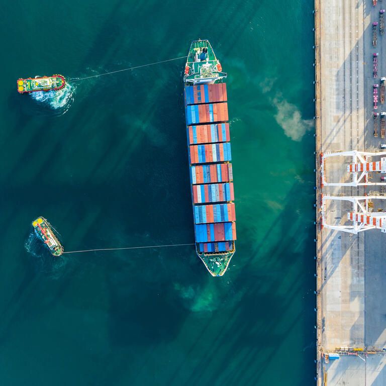 Aerial view. Container ship in pier with crane bridge carries out export and import business in the open sea